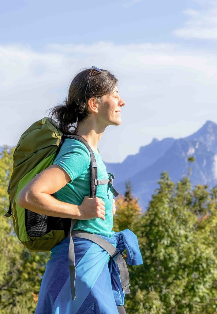 Viktoria Strasser auf einem Berg mit Rucksack und geschlossenen Augen